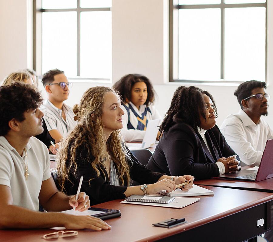 a group of students sitting in a classroom listening to a lecture